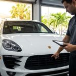 Technician calibrating front bumper camera on modern vehicle